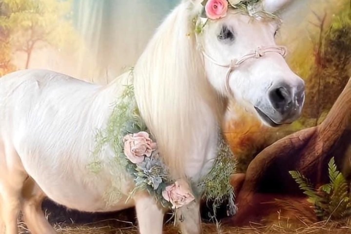 A white unicorn with a flower crown in a mystical forest setting.